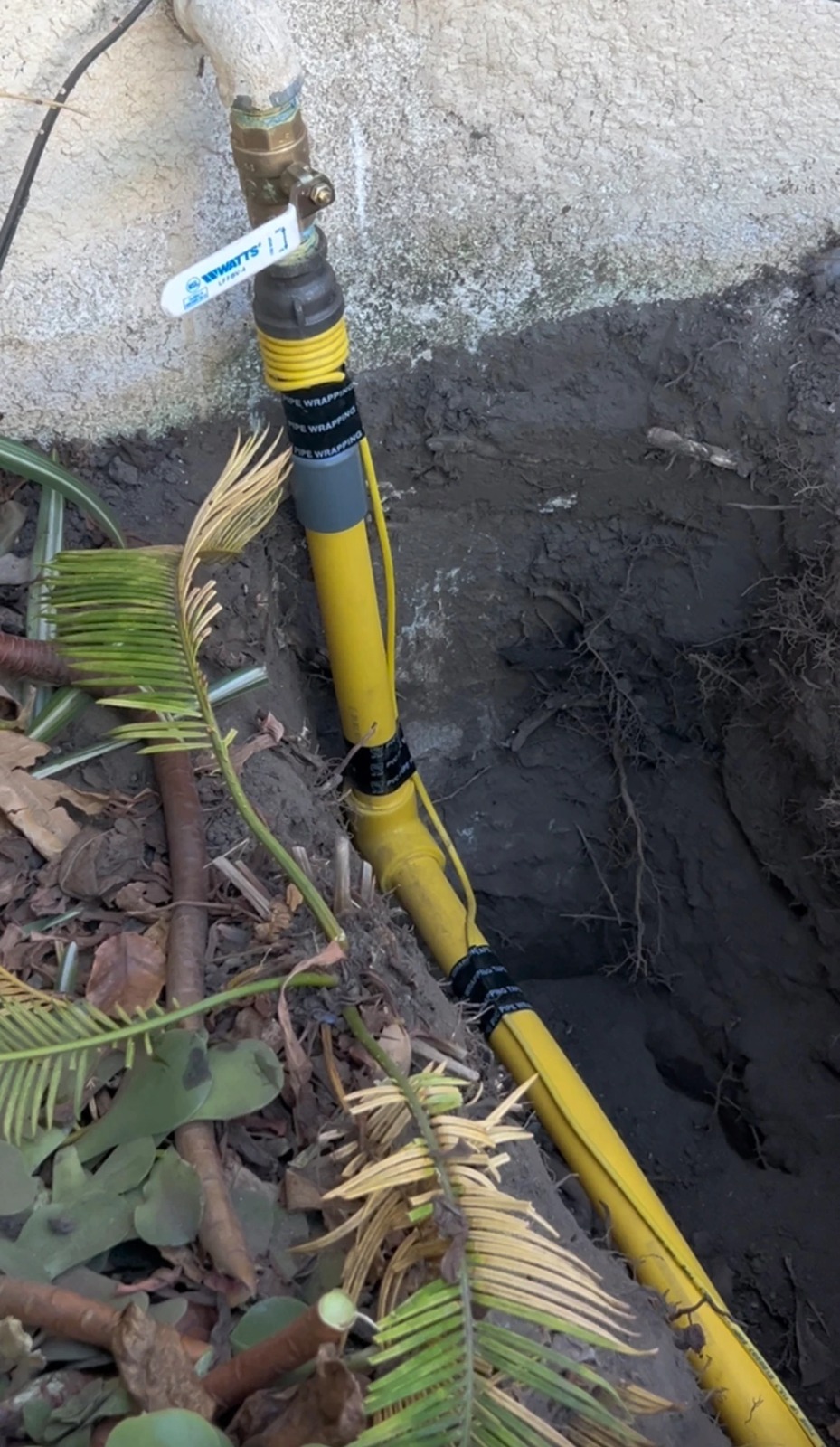 Finished yellow gas line installation with valve and connections visible
